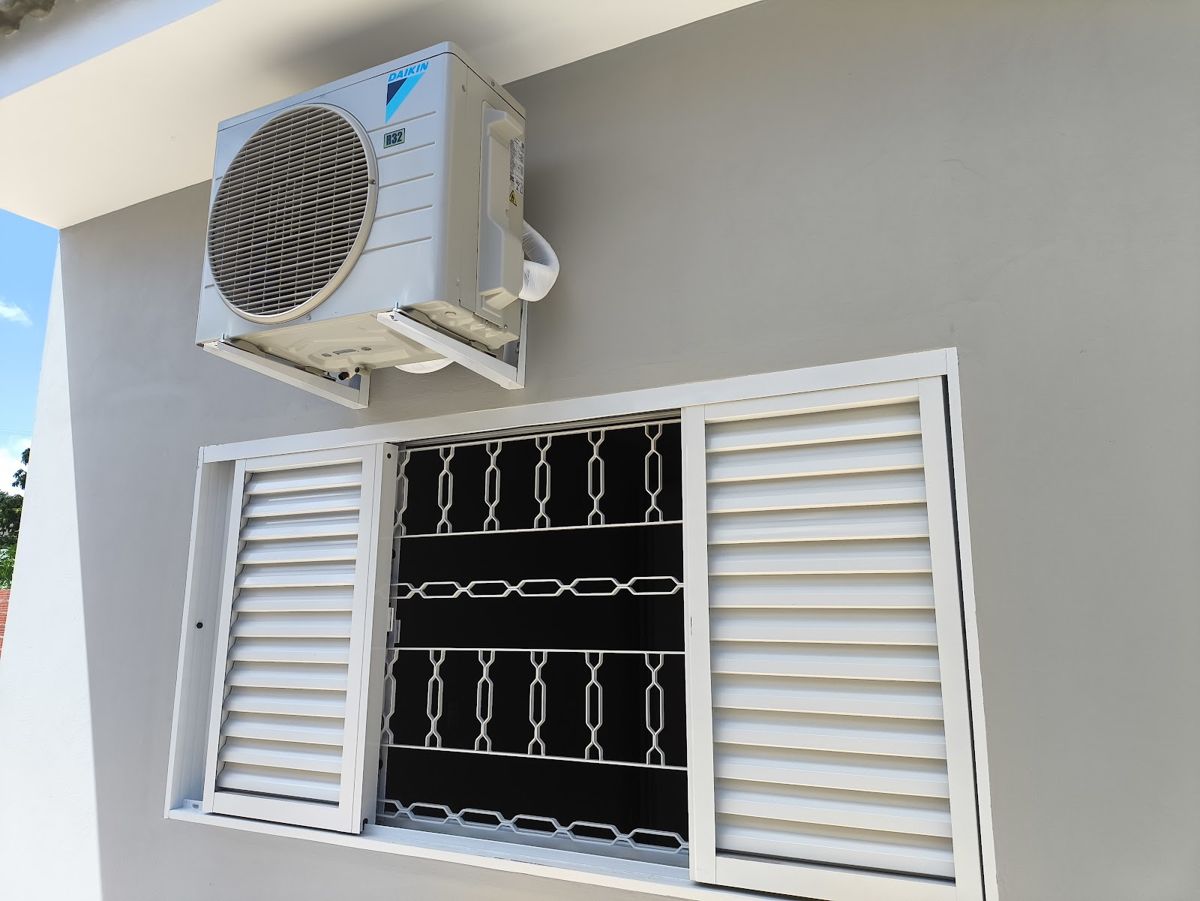 Condensadora Daikin instalada na parede acima de uma janela