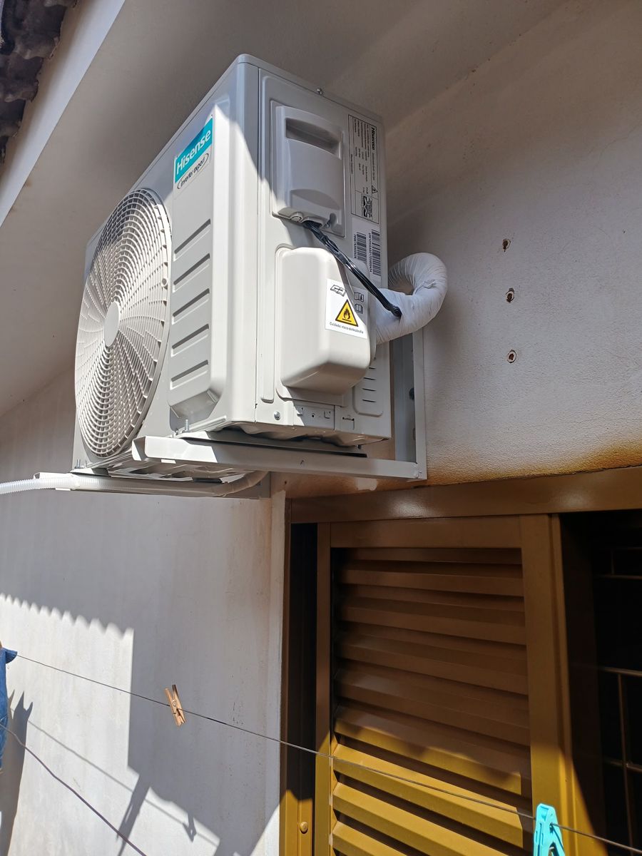 Condensadora Hisense instalada em suporte na parede externa de uma casa
